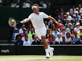Roger Federer of Switzerland stretches to make a return during the Gentlemen's Singles Final match against Novak Djokovic on July 6, 2014