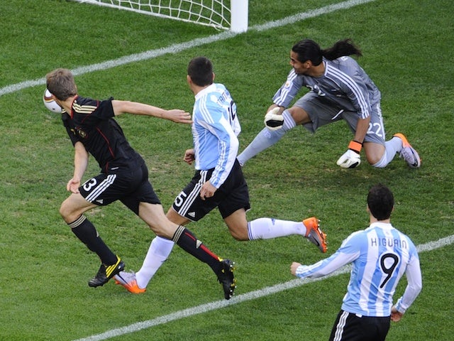 Germany's midfielder Thomas Mueller (L) scores the opening goal past Argentina's goalkeeper Sergio Romero (back, R) during the 2010 World Cup quarter-final football match on July 3, 2010