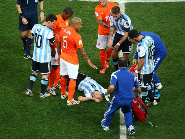 Javier Mascherano of Argentina receives treatment after a collision during the 2014 FIFA World Cup Brazil Semi Final match between the Netherlands and Argentina at Arena de Sao Paulo on July 9, 2014