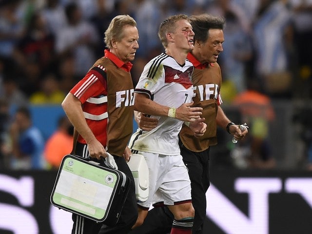 Germany's midfielder Bastian Schweinsteiger (C) is escorted off the pitch by medics after clashing with Argentina's forward Sergio Aguero (unseen)during the final football match on July 13, 2014