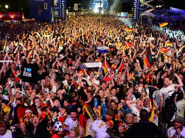 German fans react at the end of the FIFA World Cup 2014 final football match Germany vs Argentina played in Brazil during an outdoor screening near the Brandenburg Gate in Berlin, on July 13, 2014