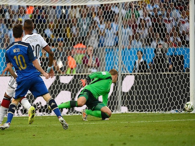 Argentina's forward and captain Lionel Messi (front) misses a shot on goal during the first half of the 2014 FIFA World Cup final football match on July 13, 2014
