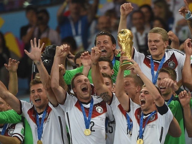 Germany's defender and captain Philipp Lahm (front-R) holds up the World Cup trophy as he celebrates with his teammates after winning the 2014 FIFA World Cup final football match on July 13, 2014