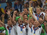 Germany's defender and captain Philipp Lahm (front-R) holds up the World Cup trophy as he celebrates with his teammates after winning the 2014 FIFA World Cup final football match on July 13, 2014