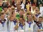 Germany's defender and captain Philipp Lahm (front-R) holds up the World Cup trophy as he celebrates on with his teammates after winning the 2014 FIFA World Cup final on July 13, 2014