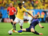 Ron Vlaar of the Netherlands challenges Paulinho of Brazil during the 2014 FIFA World Cup Brazil Third Place Playoff match on July 12, 2014