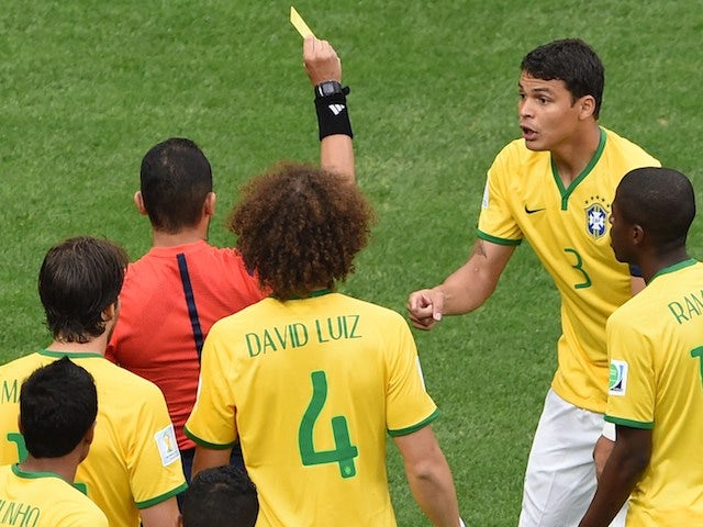 Algerian referee Djamel Haimoudi (L) gives Brazil's defender and captain Thiago Silva a yellow card after he commited a foul on Netherlands' forward Arjen Robben on July 12, 2014