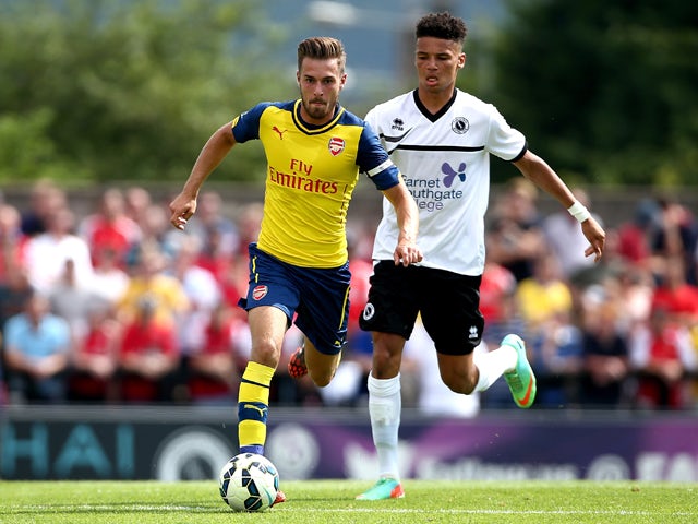 Aaron Ramsey of Arsenal tackles with Lee Angol of Boreham Wood during the pre season friendly match between Borehamwood and Arsenal at Meadow Park on July 19, 2014