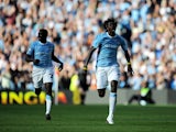 Emmanuel Adebayor of Manchester City runs towards the Arsenal fans as he celebrates scoring with team-mate Kolo Toure during the Barclays Premier League match between Manchester City and Arsenal at the City of Manchester Stadium on September 12, 2009