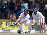 South Africa cricketer AB de Villiers is watched by Sri Lankan wicketkeeper Dinesh Chandimal as he plays a shot during the fourth day of the opening Test match between Sri Lanka and South Africa at the Galle International Cricket Stadium in Galle on July 