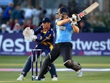Luke Wright of Sussex hits out while Mark Wallace of Glamorgan looks on during the Natwest T20 Blast match between Sussex Sharks and Glamorgan at The BrightonAndHoveJobs.com County Ground on July 15, 2014