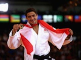 Ashley McKenzie flashes his gold medal earned in the men's -60kg judo on July 24, 2014