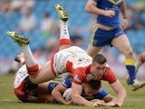 Matthew Russell of Warrington Wolves is tackled by Jonny Lomax and Joe Greenwood of St Helens during the Super League match between Warrington Wolves and St Helens at Etihad Stadium on May 18, 2014