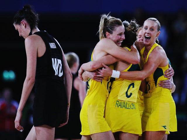 Anna Harrison of New Zealand walks off as Laura Geitz, Kimberley Ravaillion and Renae Hallinan of Australia celebrate winning the gold medal match between Australia and New Zealand at SECC Precinct during day eleven of the Glasgow 2014 Commonwealth Games 