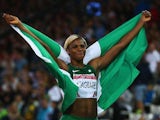 Blessing Okagbare stands proudly with the Nigerian flag after winning gold in the women's 100m on July 28, 2014