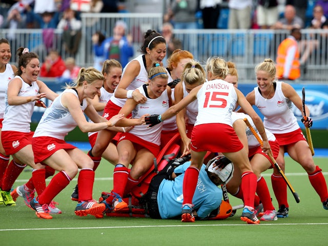 Goalkeeper Maddie Hinch of England is mobbed by her teammates as she saves the deciding penalty shuttle to put England through to the Gold Medal final during the Women's Hockey Semi Final between New Zealand and England at Glasgow National Hockey Centre d