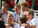 Prince Harry poses for a photograph with the England women's hockey team on July 28, 2014