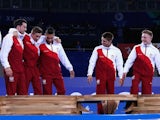 Gymnast Sam Oldham is helped onto the top of the podium by England teammates Kristian Thomas and Louis Smith, with Max Whitlock and Nile Wilson watching on, after they won team gold in the Commonwealth Games on July 29, 2014