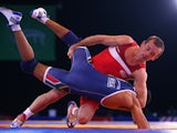 Sasha Madyarchyk of England lifts Marno Plaatjies of South Africa in the Men's 61kg Wrestling at Scottish Exhibition And Conference Centre during day seven of the Glasgow 2014 Commonwealth Games on July 30, 2014