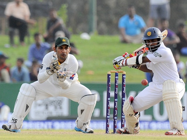 Sri Lankan cricketer Kaushal Silva is watched by Pakistan wicketkeeper Sarfraz Ahmed as he plays a shot during the second day of the opening Test match between Sri Lanka and Pakistan at the Galle International Cricket Stadium in Galle on August 7, 2014