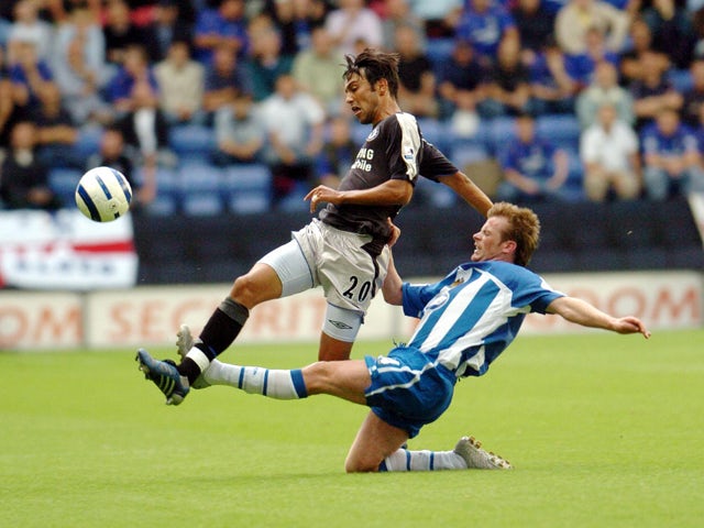 Chelsea's Paulo Ferreira is tackled by Wigan's Alan Mahon during today's premiership clash at the JJB Stadium, in Wigan 14 August 200
