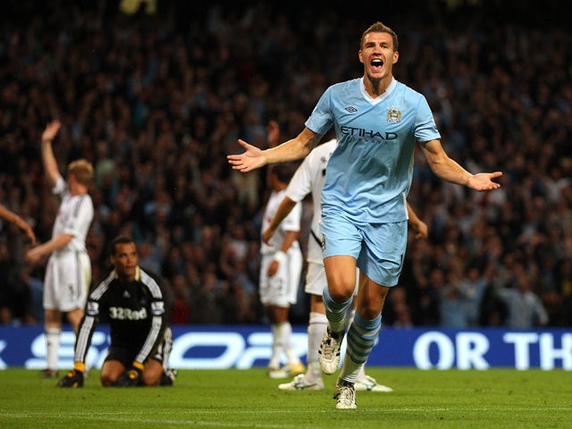 Edin Dzeko of Manchester City celebrates after scoring the opening goal during the Barclays Premier League match between Manchester City and Swansea City at Etihad Stadium on August 15, 2011