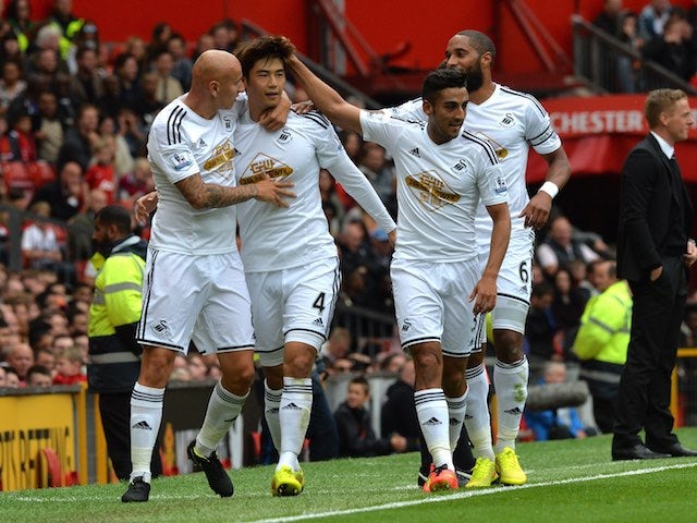 Ki Sung-Yeung is congratulated by his Swansea teammates after scoring the opener against Man United on August 16, 2014