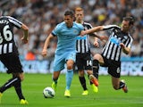 Newcastle player Mike Williamson challenges Stevan Jovetic during the Barclays Premier League match between Newcastle United and Manchester City at St James' Park on August 17, 2014
