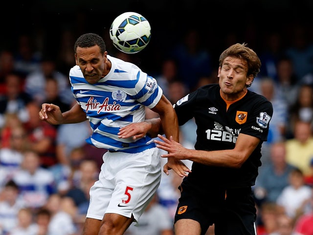 Rio Ferdinand of QPR and Nikica Jelevic of Hull City during the Barclays Premier League match between Queens Park Rangers and Hull City at Loftus Road on August 16, 2014