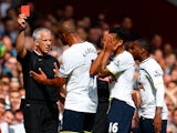 Kyle Naughton of Spurs reacts after receiving a red card for handball as Younes Kaboul of Spurs remenstrates with referee Chris Foy during the Barclays Premier League match between West Ham United and Tottenham Hotspur at Boleyn Ground on August 16, 2014