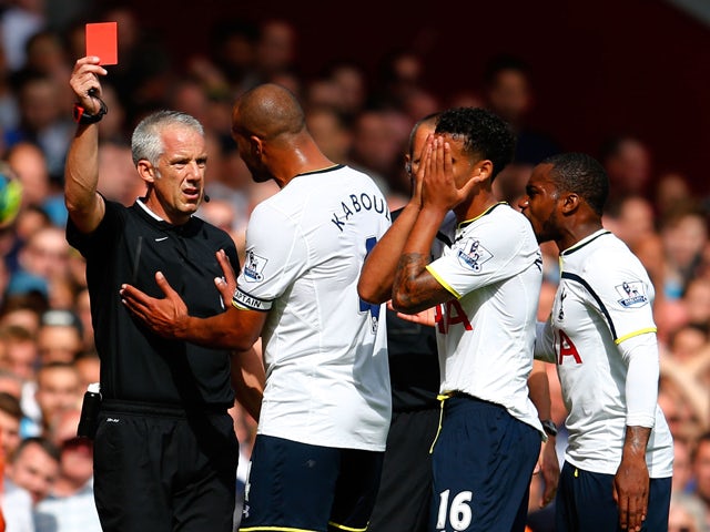 Kyle Naughton of Spurs reacts after receiving a red card for handball as Younes Kaboul of Spurs remenstrates with referee Chris Foy during the Barclays Premier League match between West Ham United and Tottenham Hotspur at Boleyn Ground on August 16, 2014