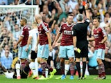 James Collins of West Ham walks off the pitch as referee Chris Foy shows him the the red card for his second bookable offence during the Barclays Premier League match between West Ham United and Tottenham Hotspur at Boleyn Ground on August 16, 2014