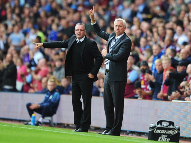 Manager Paul Lambert of Aston Villa gives instructions with Alan Pardew, manager of Newcastle United during the Barclays Premier League match between Aston Villa and Newcastle United at Villa Park on August 23, 2014
