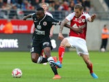 Caen's French Guinean forward Bangaly-Fode Koita vies with Reims' French midfielder Antoine Devaux during the French L1 football match Reims (SR) vs Caen (SMC) on August 23, 2014