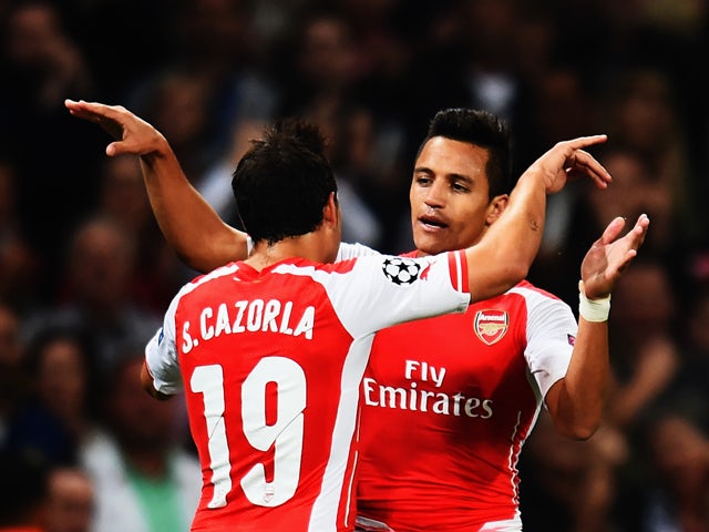 Alexis Sanchez of Arsenal celebrates with team mate Santi Cazorla of Arsenal after scoring during the UEFA Champions League Qualifier 2nd leg match between Arsenal and Besiktas at the Emirates Stadium on August 27, 2014