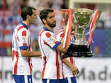 Atletico Madrid's midfielder Raul Garcia carries the 2013-2014 Spanish Liga Champions trophy before the Spanish league football match Club Atletico de Madrid vs S.D Eibar at the Vicente Calderon stadium in Madrid on August 30, 2014