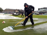 Groundsmen attempt to clear water from the pitch following heavy rain that cancelled the first One Day International (ODI) cricket match between England and India at the County Ground in Bristol, south-west England, on August 25, 2014