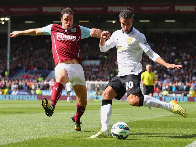 Robin van Persie of Manchester United and Michael Duff of Burnley battle for the ball during the Barclays Premier League match between Burnley and Manchester United at Turf Moor on August 30, 2014