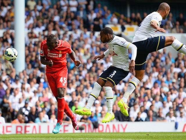 Mario Balotelli of Liverpool heads the ball under pressure from Danny Rose and Younes Kaboul of Spurs during the Barclays Premier League match on August 31, 2014