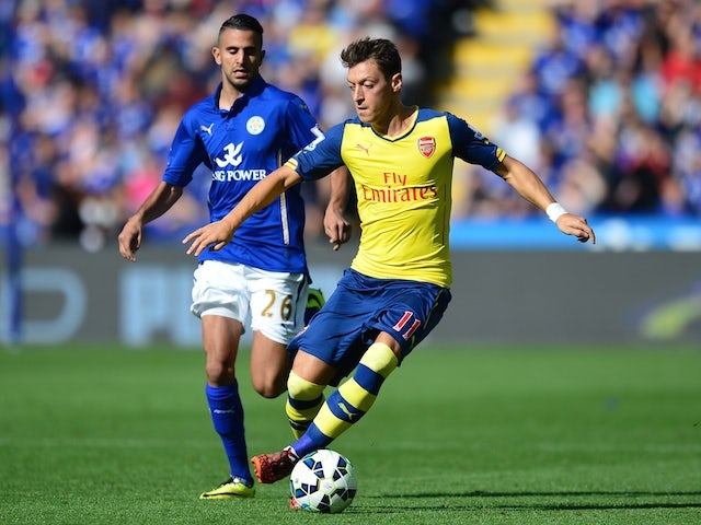 Arsenal's German midfielder Mesut Ozil (R) runs with the ball chased by Leicester City's Algerian midfielder Riyad Mahrez (L) during the English Premier League football match on August 31, 2014