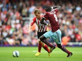 Steven Davis of Southampton is challenged by Cheikhou Kouyate of West Ham United during the Barclays Premier League match between West Ham United and Southampton at Boleyn Ground on August 30, 2014