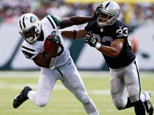Chris Ivory #33 of the New York Jets stiffarms Tyvon Branch #33 of the Oakland Raiders during the second quarter at MetLife Stadium on September 7, 2014 