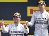British driver Lewis Hamilton celebrates next to second placed Mercedes' German driver Nico Rosberg on the podium after the Italian Formula One Grand Prix motor race at the Autodromo Nazionale circuit in Monza on September 7, 2014