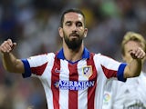 Atletico Madrid's Turkish midfielder Arda Turan (top) celebrates with Atletico Madrid's French forward Antoine Griezmann after scoring during the Spanish league football match against Real Madrid on September 13, 2014