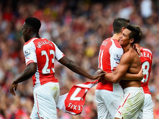 Alexis Sanchez of Arsenal celebrates scoring their second goal with Mesut Oezil and Danny Welbeck of Arsenal during the Barclays Premier League match between Arsenal and Manchester City at Emirates Stadium on September 13, 2014
