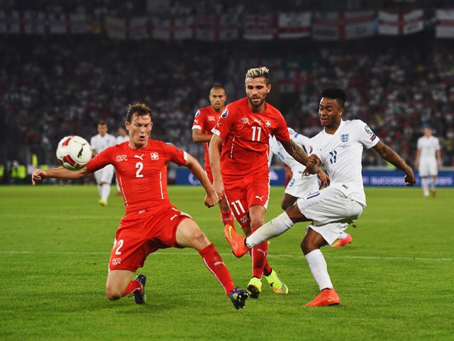 Raheem Sterling of England shoots past Stephan Lichtsteiner (2) and Valon Behrami of Switzerland (11) during the UEFA EURO 2016 Group E qualifying match between Switzerland and England at St Jakob-Park on September 8, 2014