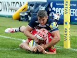 Rob Cook of Gloucester Rugby scores a try in the corner as Tom Brady of Sale Sharks tries to tackle during the Aviva Premiership match between Gloucester Rugby and Sales Sharks at Kingsholm on September 13, 2014