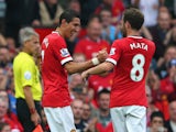 Angel Di Maria of Manchester United is congratulated by team-mate Juan Mata after scoring the first goal during the Barclays Premier League match between Manchester United and Queens Park Rangers at Old Trafford on September 14, 2014