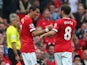 Angel Di Maria of Manchester United is congratulated by team-mate Juan Mata after scoring the first goal during the Barclays Premier League match between Manchester United and Queens Park Rangers at Old Trafford on September 14, 2014