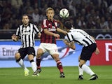 AC Milan's japanese forward Keisuke Honda (C) fights for the ball with Juventus defender Leonardo Bonucci on September 20, 2014